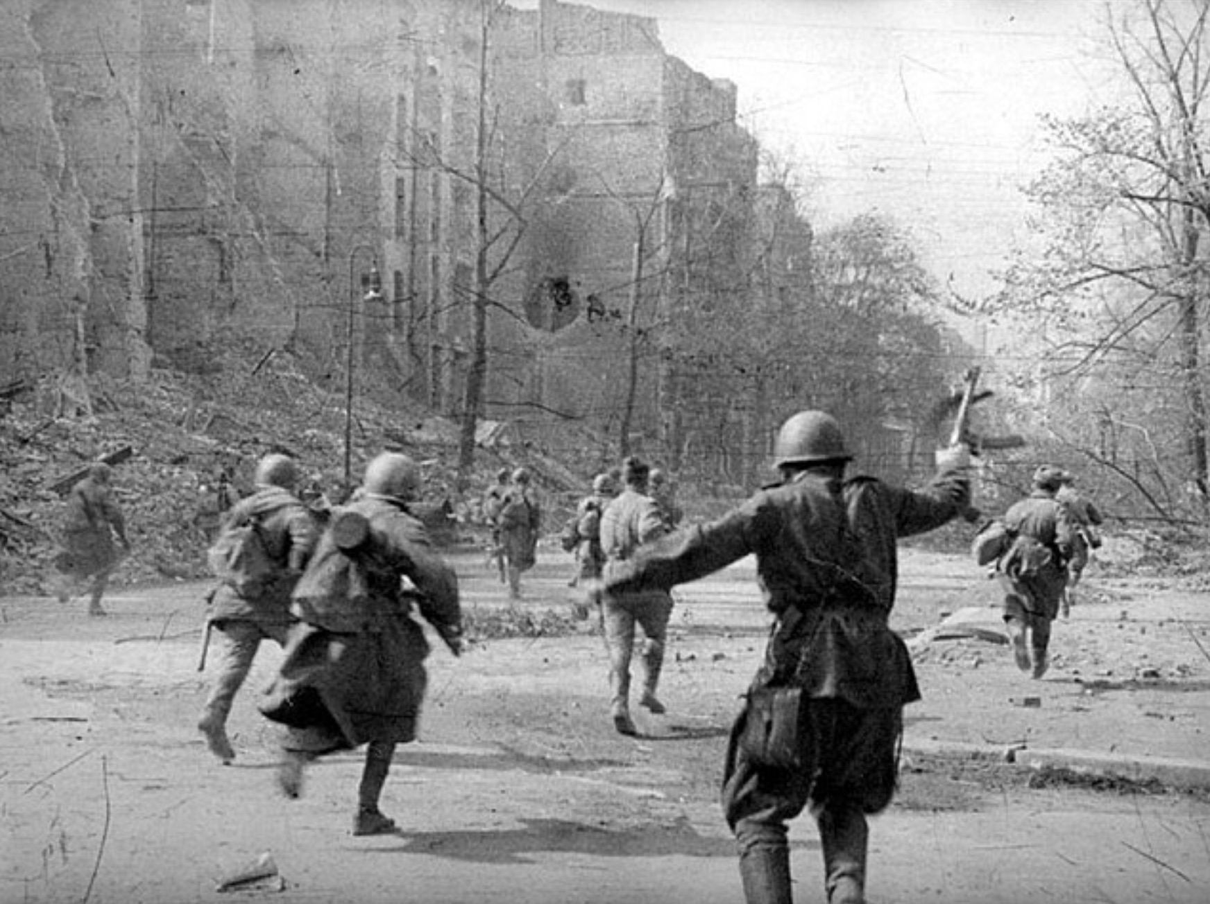 Soviet soldiers run to attack on the streets of Berlin. 